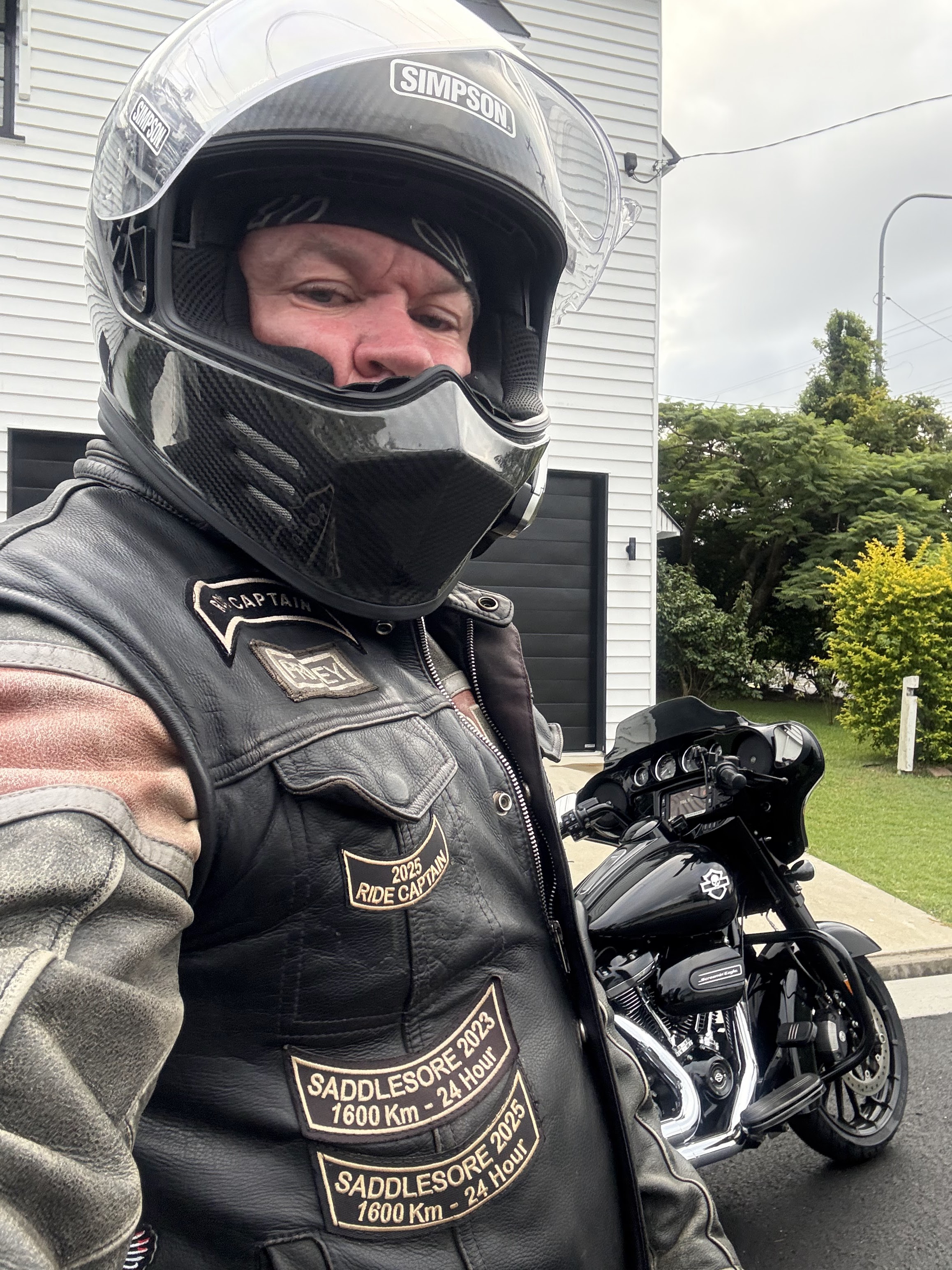 Geared up and ready to roll — Simpson lid, leather vest, patches on display